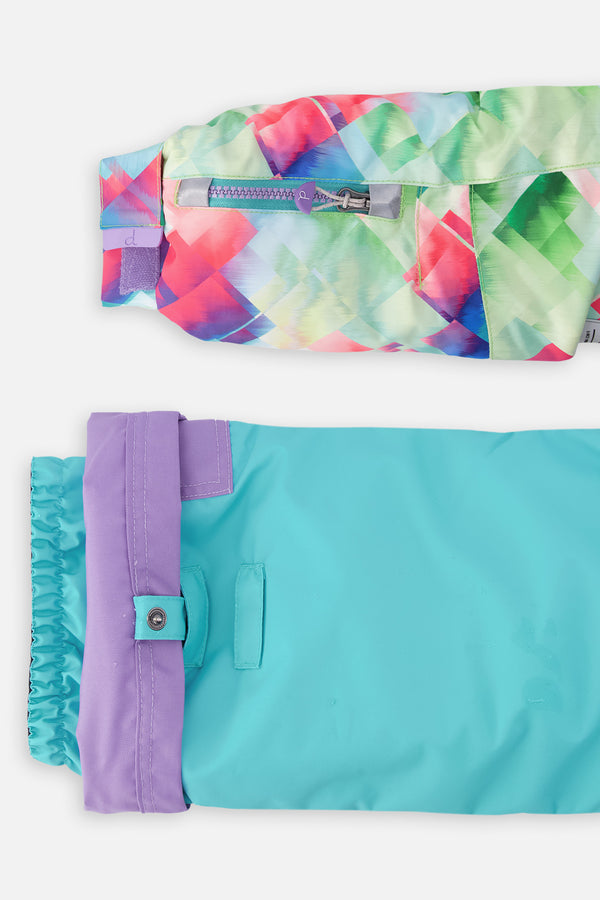 Zweiteiliger Spiel-Schneeanzug in mehreren Farben mit Rautenmuster, türkisfarbener Jacke und violetten Hosen